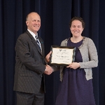 Doctor Potteiger posing for a photo with an award recipient in a grey sweater and purple dress